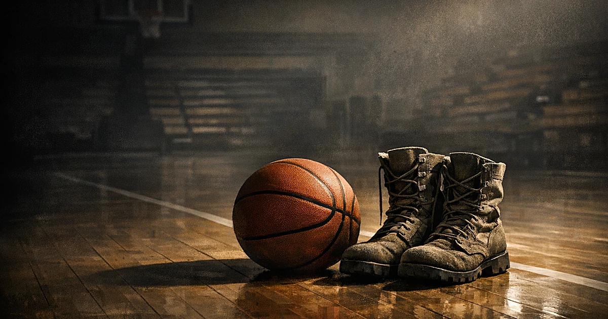 Basketball and military combat boots on empty hardwood court with dramatic lighting and long shadows