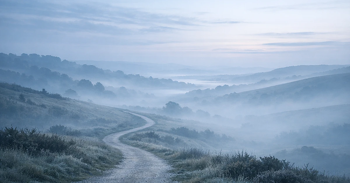 Abstract landscape with winding path through misty hills toward horizon in soft blue and gray tones